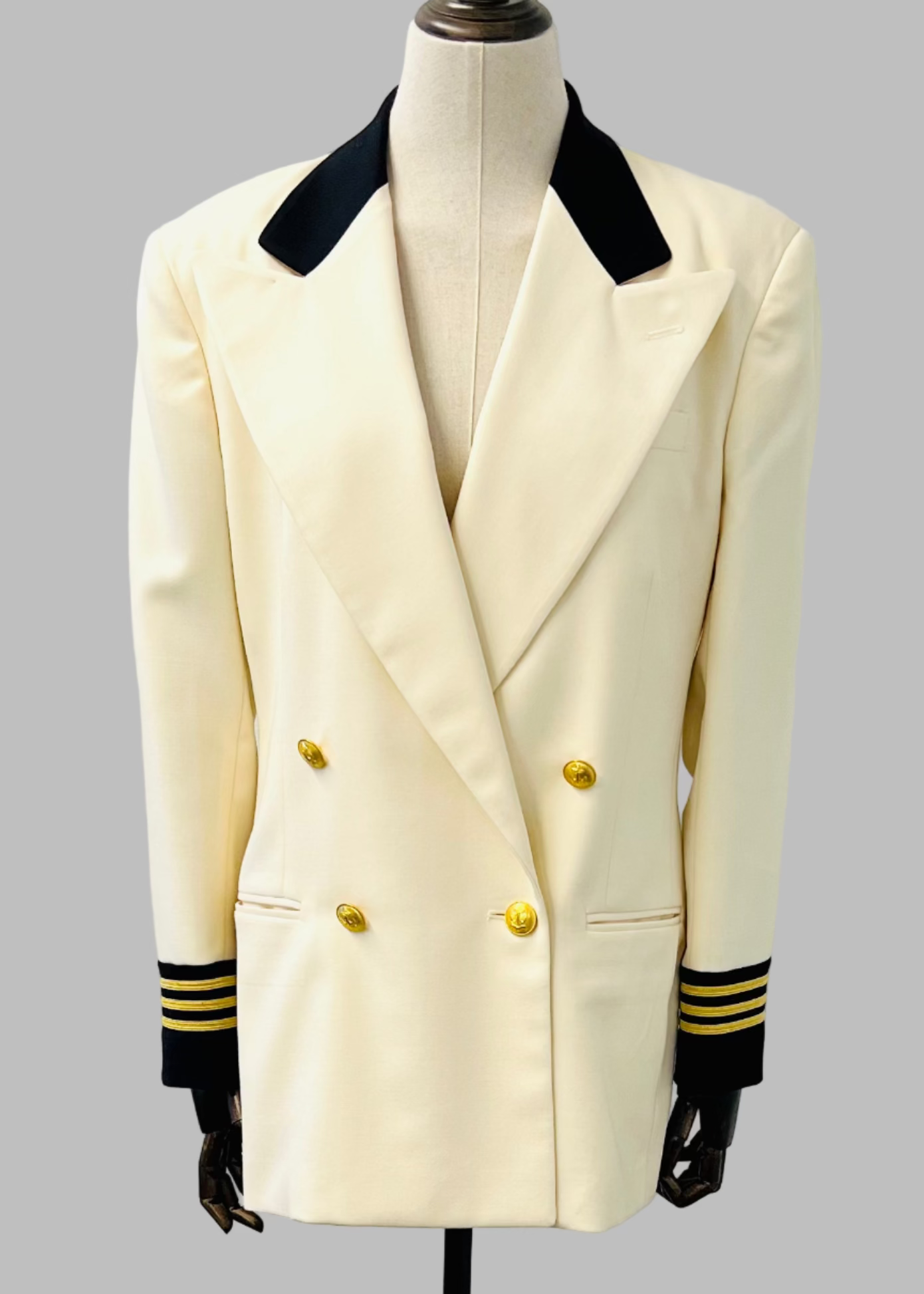 White naval jacket with black collar and cuffs on a mannequin against a gray background