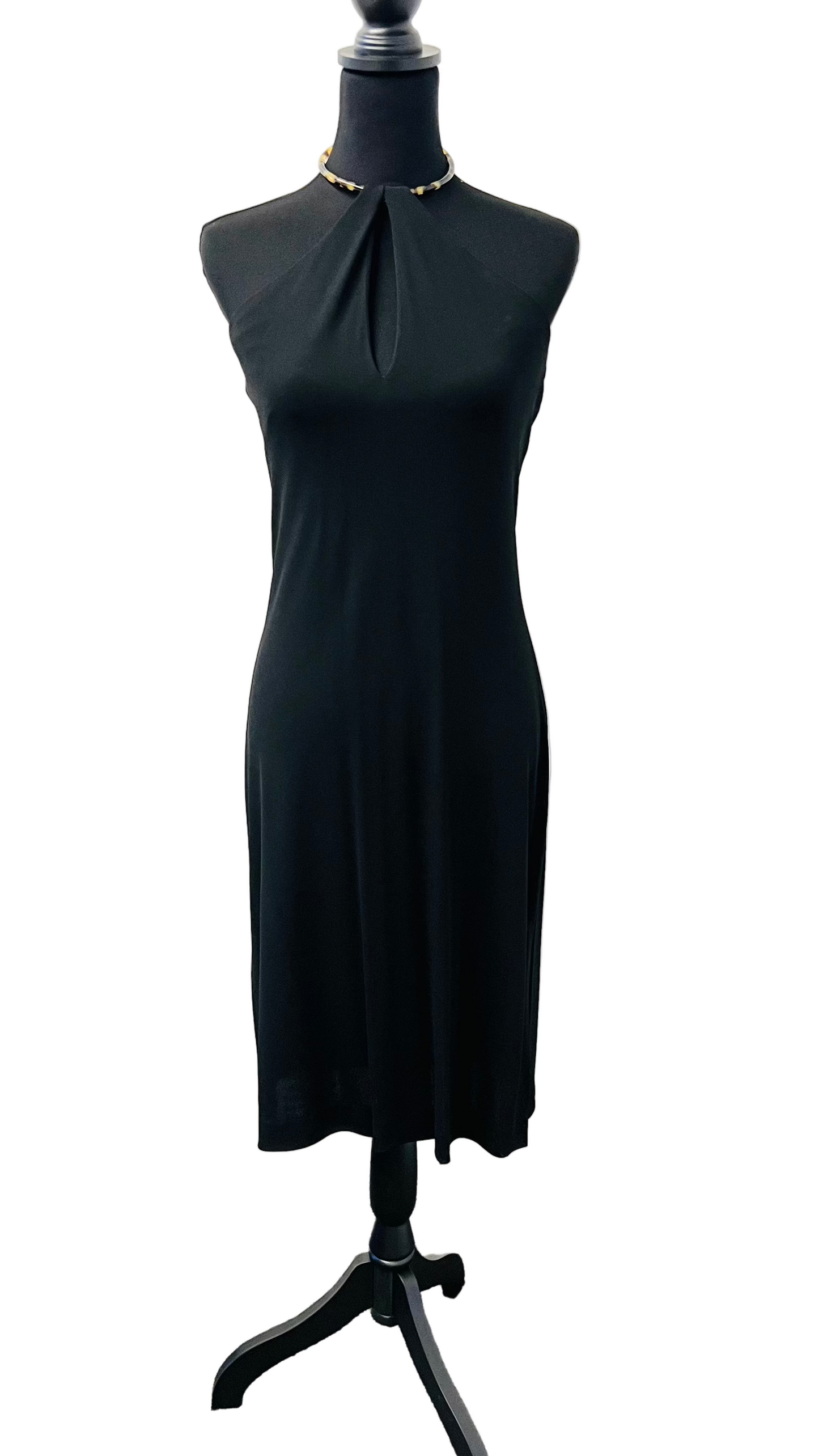 A black crepe dress with a tortise shell choker necklace on a mannequin against a white background.