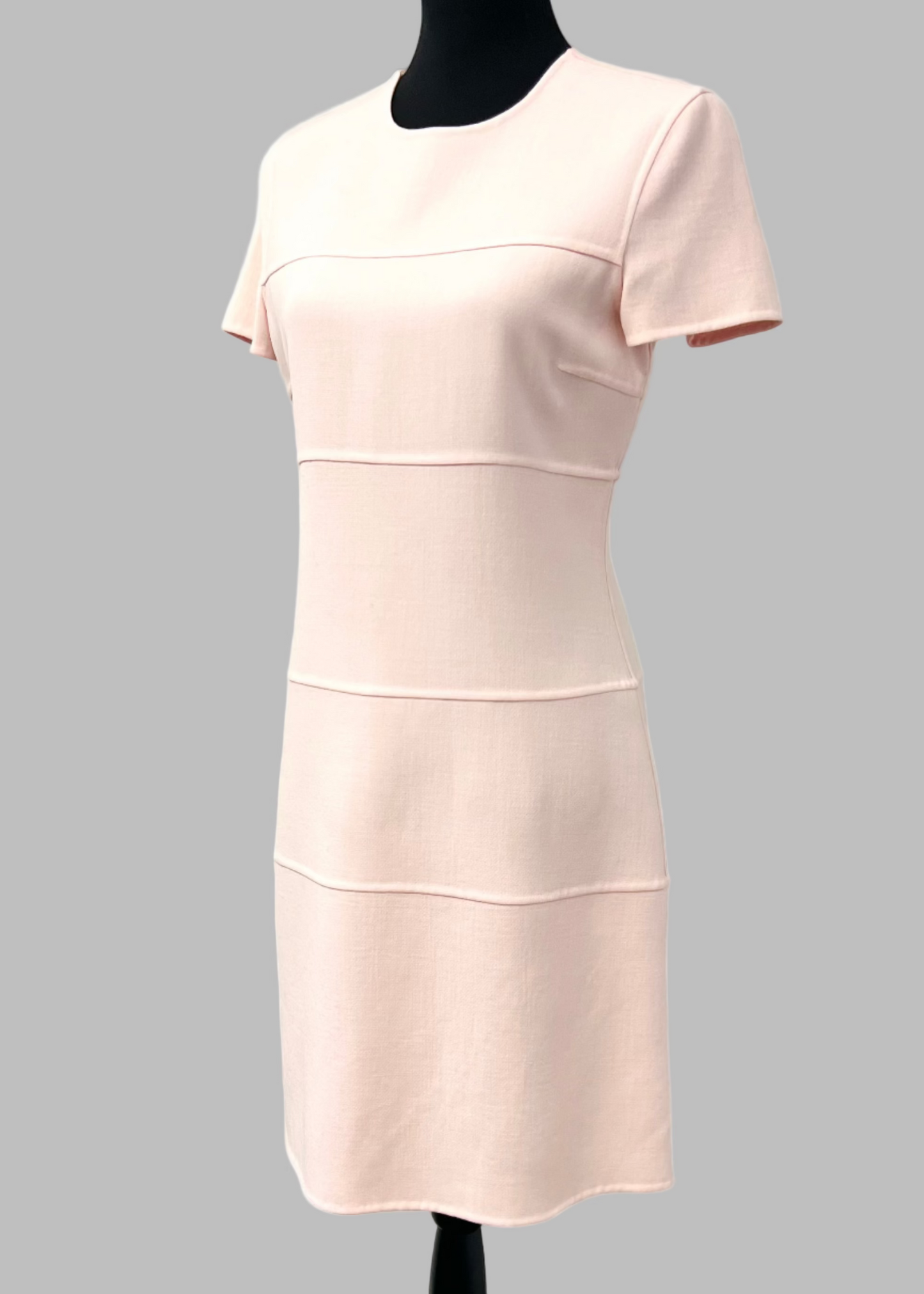 A petal pink cap sleeve wool dress on a mannequin against a plain background.