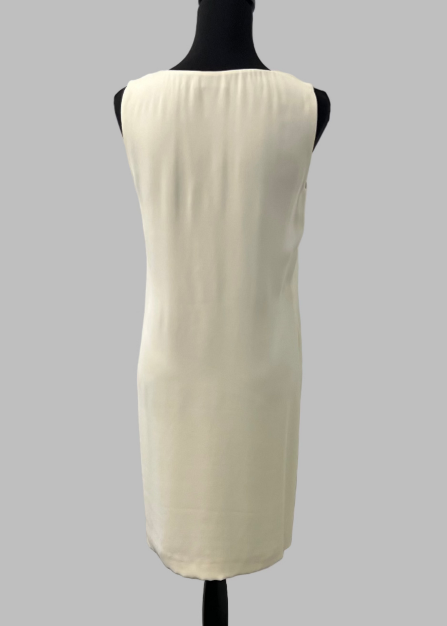 White sleeveless dress on a mannequin against a gray background