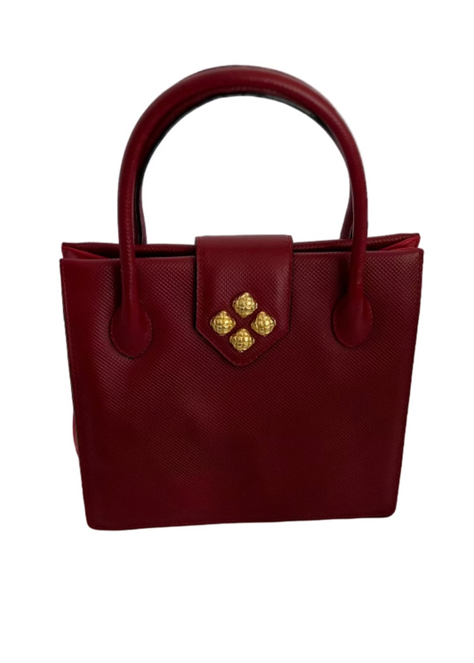 Red handbag with gold accents on a light gray surface