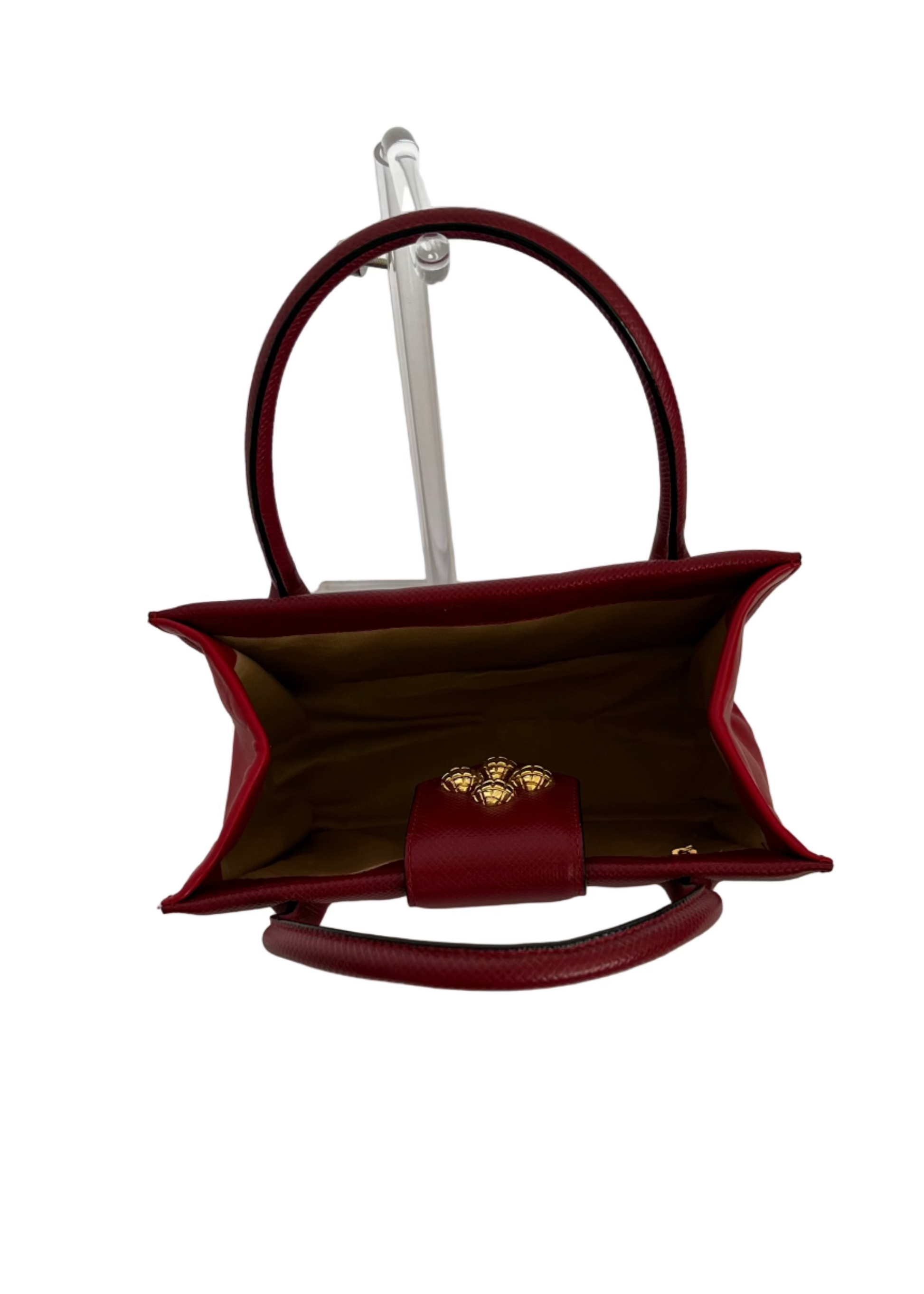 Red handbag with gold clasp on a white background