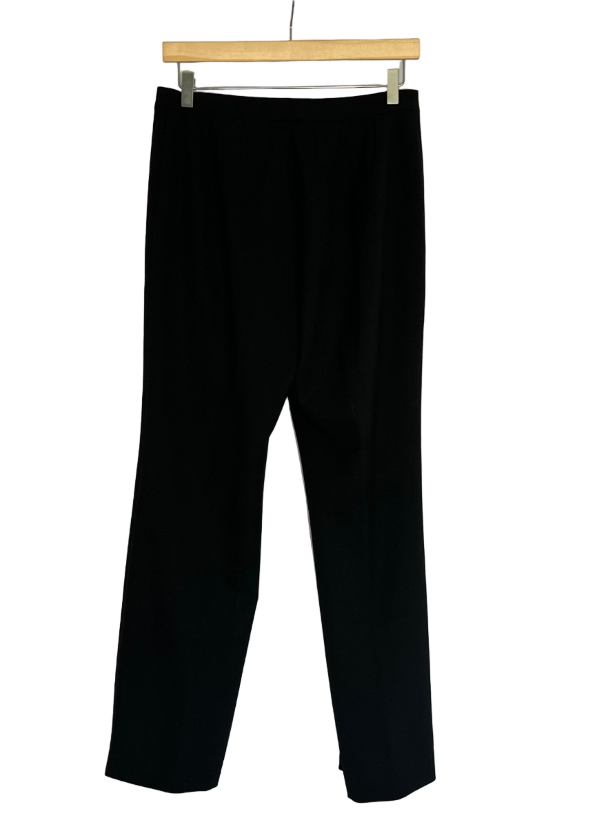Black pants hanging on a wooden hanger against a white background